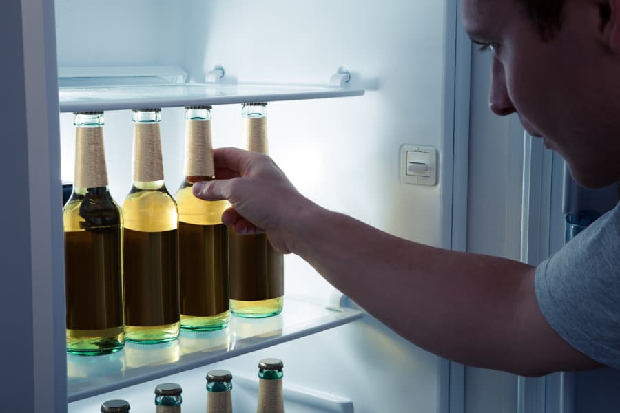 Beer bottles perfectly aligned in fridge and stored at ideal temperature 