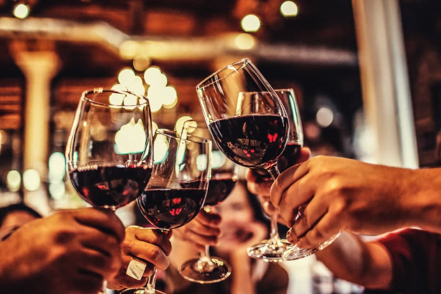 Five friends raise wine glasses in a toast 