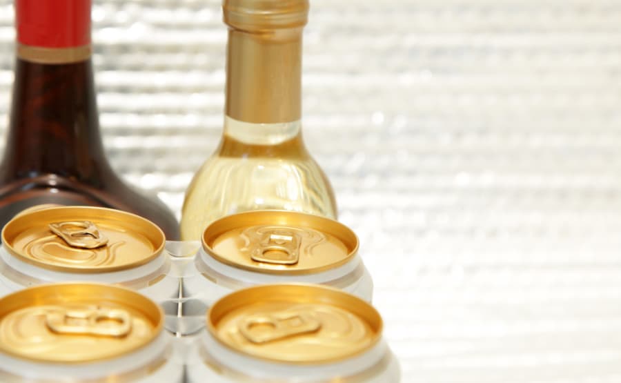 Pack of canned wine in front of bottles of red and white wine